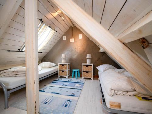 a attic bedroom with two beds and a window at Tuzzetje in Nieuwpoort
