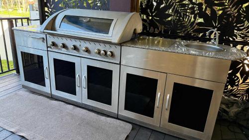 a stove with a microwave on top of it at Waterlink Retreat in South Yunderup