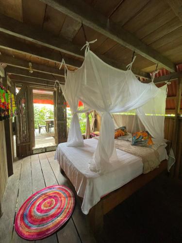 a bedroom with a bed with a mosquito net at Salvaje trip in Nuquí