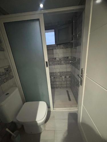 a bathroom with a toilet and a walk in shower at Résidence ADAM in Akouda