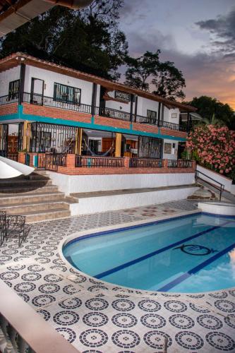 a resort with a swimming pool in front of a building at Hotel para descanso con piscina in San Gil