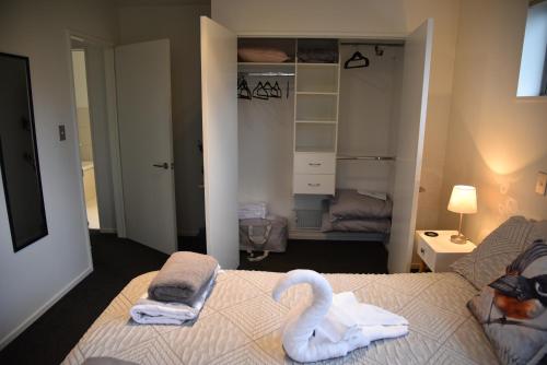 a bedroom with two swans towels on a bed at Rojan's Roost in Christchurch