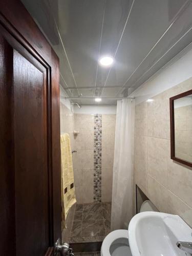 a bathroom with a shower and a toilet and a sink at Donde Emma in Salamina