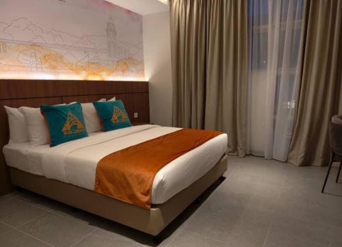 a bedroom with a large bed with blue pillows at The Jerai Hotel Sungai Petani in Sungai Petani