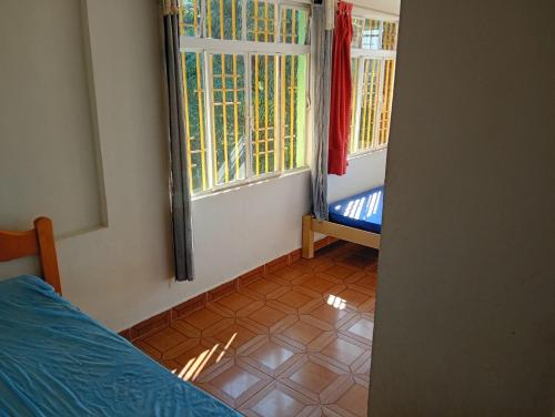 a bedroom with a bed and two windows and a tiled floor at Chácara sol nascente in Suzano