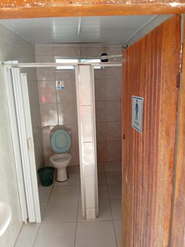 a bathroom with a toilet with a blue seat at Chácara sol nascente in Suzano