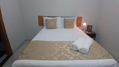 a bedroom with a bed with towels on it at Casa Tranquila com Vaga para carro em Três Lagoas in Três Lagoas