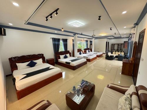 a large room with two beds and a couch at Kep Queen Boutique in Phumĭ Ŏng Char