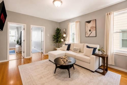 a living room with a white couch and a table at Spacious 10BD Home, 12 min NYC & MetLife in Bayonne