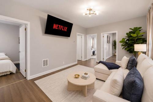 a living room with a white couch and a bed at Spacious 10BD Home, 12 min NYC & MetLife in Bayonne