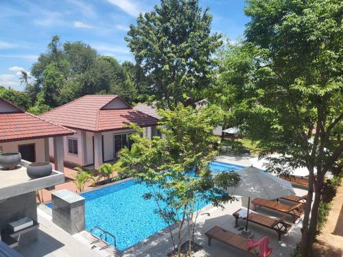 an overhead view of a swimming pool with chairs and an umbrella at Kep Queen Boutique in Phumĭ Ŏng Char