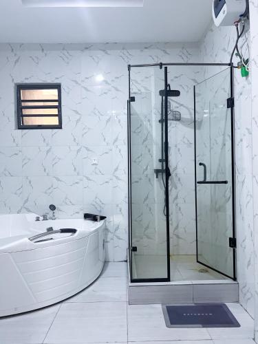a bathroom with a glass shower and a sink at Oak Atlantic Layout - OTITO Suites in Lekki