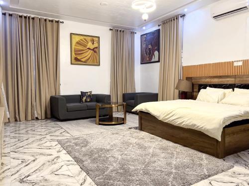a hotel room with a bed and a couch at Oak Atlantic Layout - OTITO Suites in Lekki
