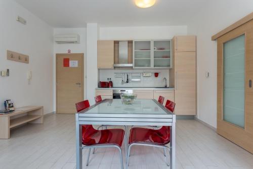 a kitchen with a table and two red chairs at Apartments Villa Alba in Dubrovnik