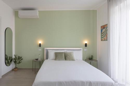 a bedroom with a large white bed with two tables at Dimore Margherita in Petacciato