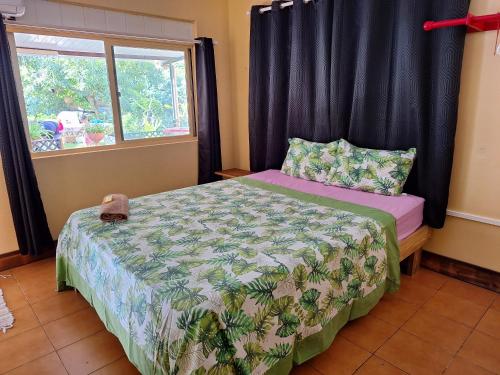 a bedroom with a bed and a window at Haekua Chez Mel in Nuku Hiva