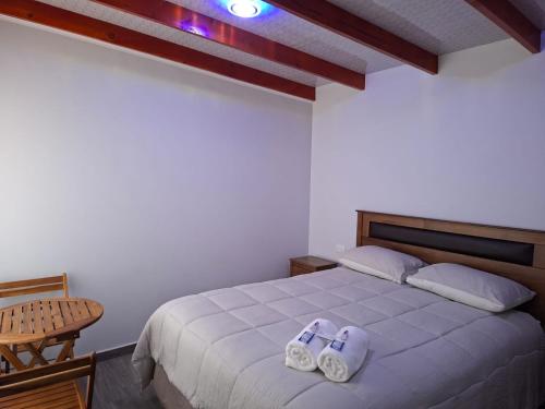 a bedroom with a bed with two slippers on it at Alto Jere in Toconao