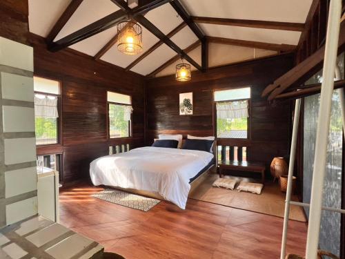 a bedroom with a bed in a room with wooden walls at Mocha Latte Homestay & Cafe in Chiang Rai