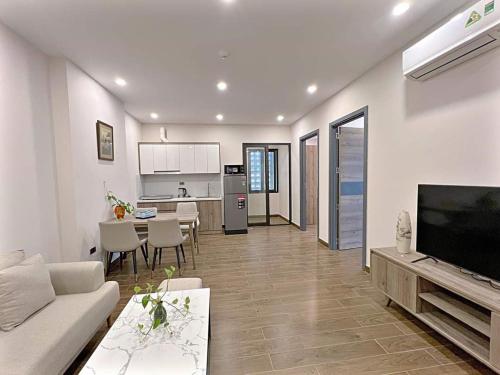 a living room with a couch and a table and a kitchen at Biệt thự Hoa Hồng Eco Central park in Ma Moi