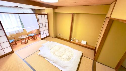 a room with a bed in the middle of a room at ATAMI SPRING TERRACE HOTEL in Atami