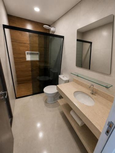 a bathroom with a sink and a toilet and a mirror at Hotel New City in Guarulhos