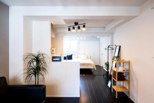a bedroom with a bed and a room with a couch at エルモス唐人 in Muromimachi