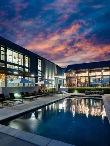 a large building with a swimming pool in front of it at Luxury Apartment Overlooking the River in Midrand