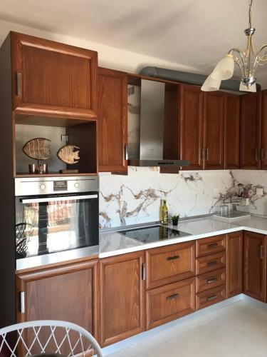 a kitchen with wooden cabinets and a stove at Aeria Elegant Luxury Villa in Asprovalta