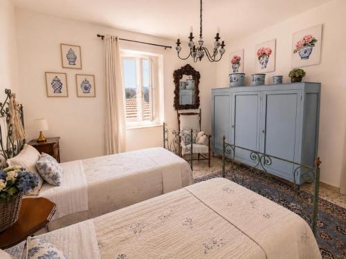 a bedroom with two beds and a blue cabinet at La Casetta in San Terenziano