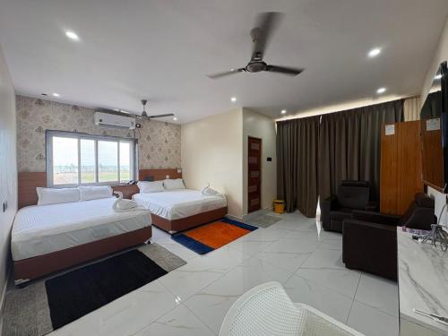 a hotel room with two beds and a couch at S R RESORTS in Chīrāla