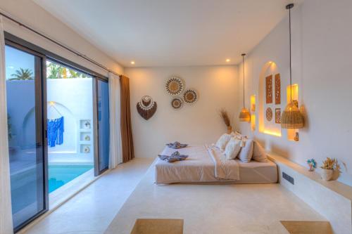 a bedroom with a bed and a large window at Villa Calipso in Gili Trawangan