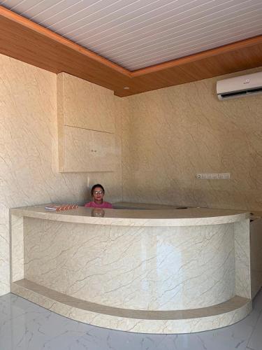 a man standing behind a counter in a room at Semar Hotel in Tjakranegara