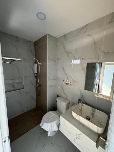 a white bathroom with a sink and a shower at เจฮอนโด อพาร์ตเมนต์ in Ban Si Than