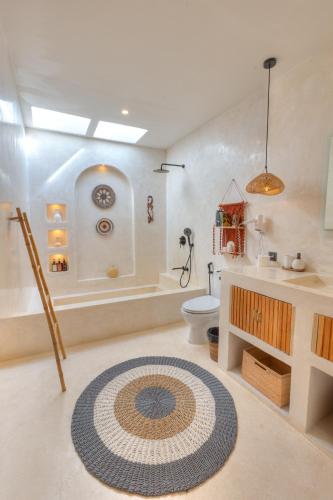 a bathroom with a tub and a toilet and a sink at Villa Afrodite in Gili Trawangan