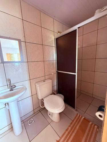 a bathroom with a toilet and a sink at Pousada Villa Cerrado in Caldas Novas