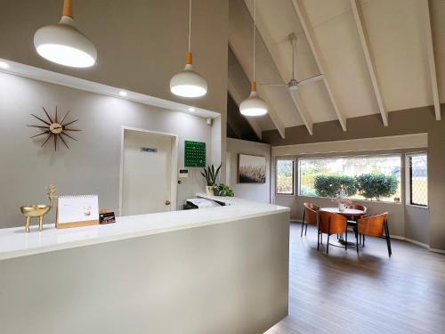 a lobby with a counter and a dining room at Airport Manor Inn in Auckland
