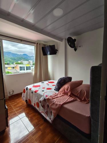 a bedroom with a bed and a large window at Bahamas House in Ibagué