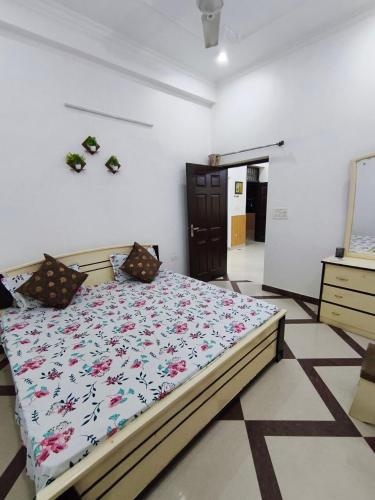 a bedroom with a bed with a floral comforter at Comfy Stay in Dehradun
