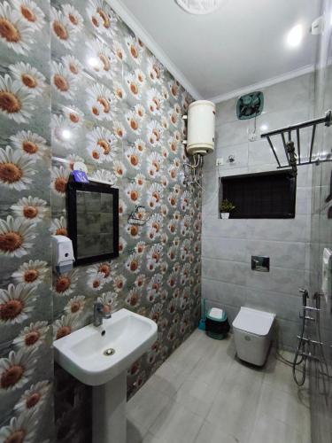 a bathroom with a sink and a flower patterned wall at Comfy Stay in Dehradun