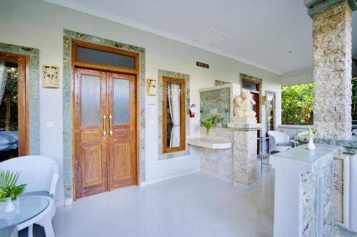 a room with a door and a table and chairs at Poinciana Resort in Tejakula