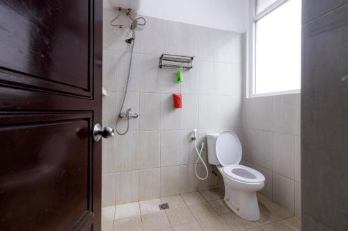 a bathroom with a toilet and a window at RedDoorz Premium @ Ampera Raya 2 in Jakarta