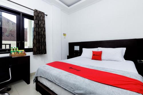 a bedroom with a bed with a red pillow on it at RedDoorz Premium @ Ampera Raya 2 in Jakarta