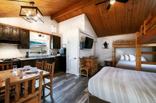 a bedroom with a bed and a kitchen and a table at Yellowstone Riverside Cottages in Gardiner