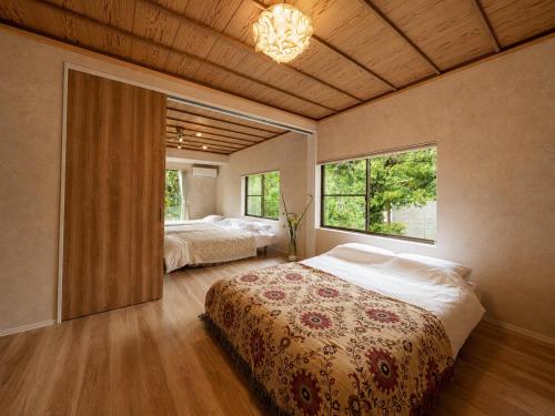 a bedroom with two beds and two windows at Knot in Shodoshima