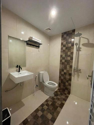 a bathroom with a toilet and a sink and a shower at Wisma SIDAPORE JD in Lamobuang