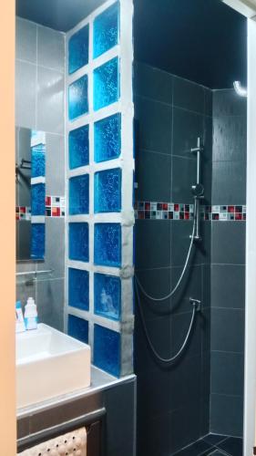 a bathroom with a sink and a shower with blue tiles at HiSSS Style ชะอำ in Cha Am