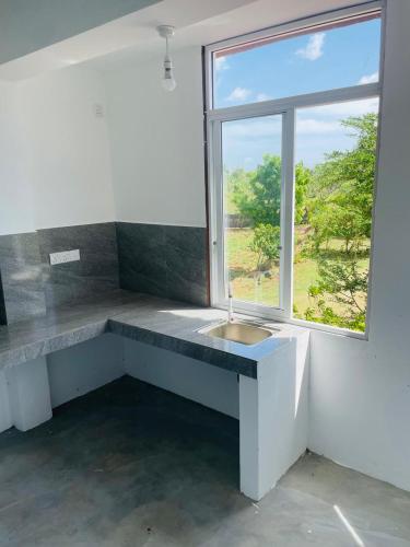 a bathroom with a sink and a window at Relax Cottage in Mailagamuwa