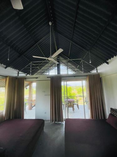 a bedroom with two beds and a ceiling fan at Relax Cottage in Mailagamuwa