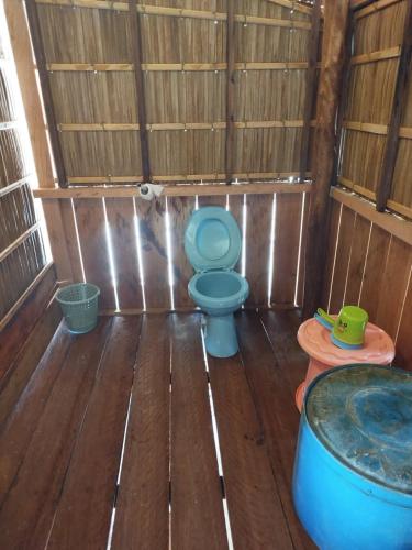 a bathroom with a blue toilet and a tub at KAINORA Guest Hause in Pulau Batanta