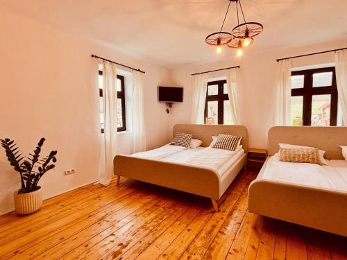 two beds in a room with wooden floors and windows at Grosser Raw in Hamba
